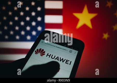 Huawei logo sur son site web est affiché sur un écran de smartphone, United States flag et République populaire de Chine drapeau flou sur l'arrière-plan Banque D'Images