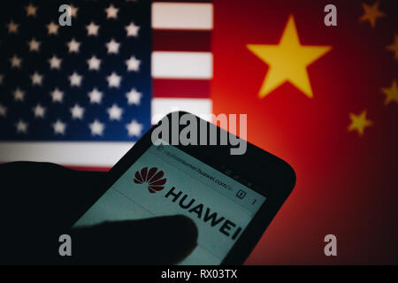 Huawei logo sur son site web est affiché sur un écran de smartphone, United States flag et République populaire de Chine drapeau flou sur l'arrière-plan Banque D'Images