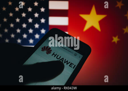 Huawei logo sur son site web est affiché sur un écran de smartphone, United States flag et République populaire de Chine drapeau flou sur l'arrière-plan Banque D'Images