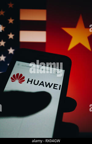 Huawei logo sur son site web est affiché sur un écran de smartphone, United States flag et République populaire de Chine drapeau flou sur l'arrière-plan Banque D'Images