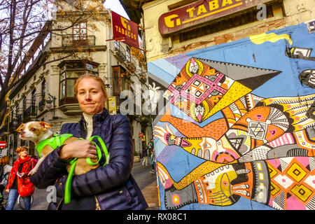 Valencia Street art View, une femme avec un chien Espagne Valence vieille ville, El Carmen Valencia rue scène Banque D'Images