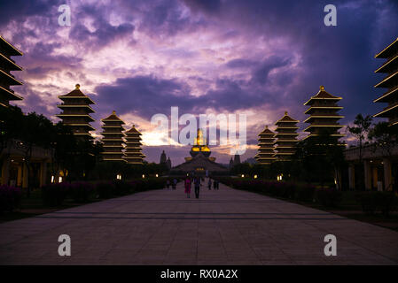 Fo Guang Shan - Plus grand monastère bouddhiste de Taïwan - l'immense Bouddha Shakyamuni à la fin d'un chemin de touristes sous un ciel coucher de soleil spectaculaire Banque D'Images