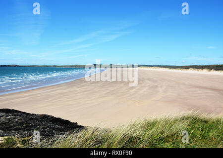 La belle plage de sable et à distance sur le côté nord de l'île Llanddwyn, qui est situé sur la magnifique île d'Anglesey en Galles du Nord. Banque D'Images