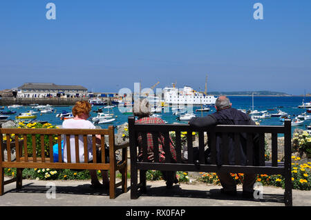 Les vacanciers appréciant la vue sur le port très fréquenté à Hugh Town, St Mary, Îles Scilly. Bien que Scillonian 3 est déchargé après il jou Banque D'Images