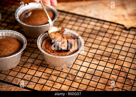 Personne de manger du gâteau au chocolat fondu close up Banque D'Images