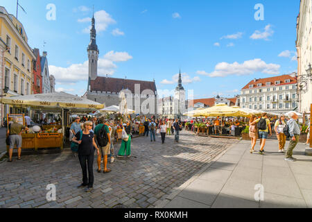 Les touristes envahissent les terrasses de cafés et boutiques de la place de la ville médiévale de Tallinn dans la ville fortifiée de Tallinn en Estonie. Banque D'Images