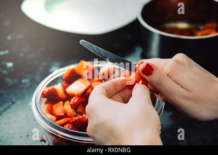 Mains Chef slicing fraises fraîches. Bol avec des fraises. Recette de fraises. Cuisine Banque D'Images