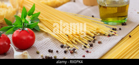 La préparation de la nourriture italienne. Les pâtes Spaghetti, Tomates, ail et poivre graines, banner Banque D'Images