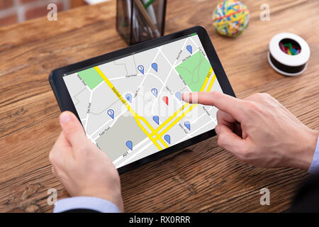 Close-up of a person's Hand en utilisant la carte GPS avec Navigation sur tablette numérique Pointeur Banque D'Images