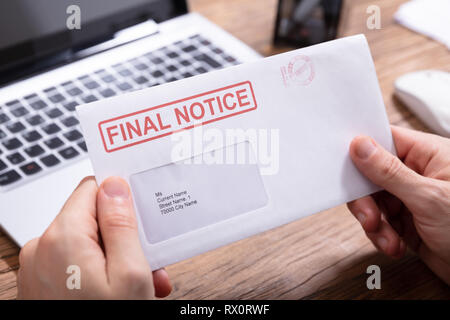 Close-up of Person's Hand Holding Avis final Envelope Banque D'Images