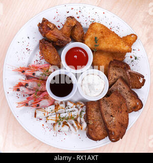 Restaurant le plat. Plaque de base de l'assortiment de collations de la bière, le saindoux, les crevettes bouillies, frites, nuggets de poulet au fromage et pain noir frit Banque D'Images