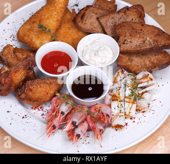 Restaurant le plat. Plaque de base de l'assortiment de collations de la bière, le saindoux, les crevettes bouillies, frites, nuggets de poulet au fromage et pain noir frit Banque D'Images