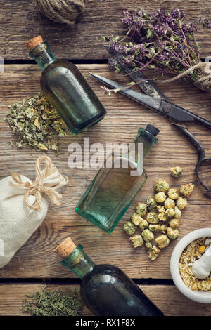 Bouteilles teinture, assortiment de plantes saines à sec, mortier, sachet, des ciseaux. La médecine de fines herbes. Haut de la vue, télévision lay. Banque D'Images