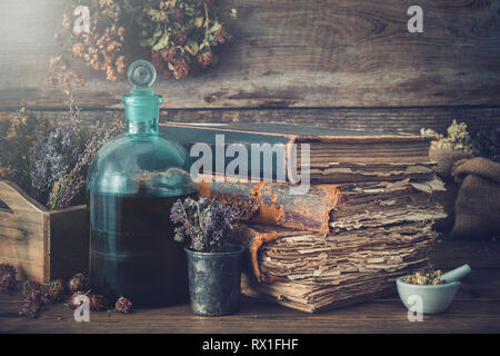 Bouteilles teinture, assortiment de plantes saines à sec, de vieux livres, mortier, les médicaments curatifs. La médecine de fines herbes. De style rétro. Banque D'Images