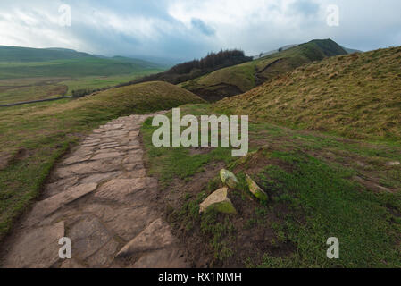 Un petit chemin rock s'exécute à travers les collines du Peak District sur une hivers brumeux jour Banque D'Images