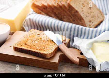 Les tranches de pain grillé, de beurre et de fromage pour le petit déjeuner. Banque D'Images