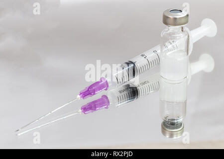 Flacons de médicaments et l'aiguille d'injection sur le miroir. Banque D'Images