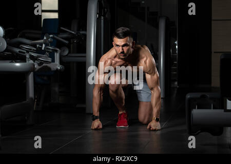 Forte des hommes musclés à genoux sur le sol - Presque comme Sprinter Position de départ Banque D'Images