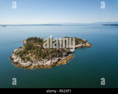 Vue aérienne d'une île rocheuse pendant une journée ensoleillée. Pris près de la rivière Powell, Sunshine Coast, en Colombie-Britannique, Canada. Banque D'Images