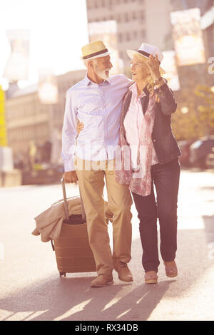 Happy happy senior couple de touristes avec la carte et guide des villes de la marche sur la rue Banque D'Images