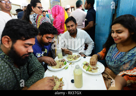 Les jeunes à la mode Bangladeshis jouissant de leurs Biriyani à l'original en Vieux Dhaka Biryani Haji. Banque D'Images