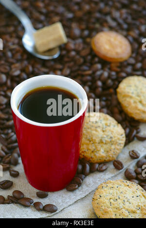 Tasse de café rouge, grains de café en vrac et les cookies Banque D'Images