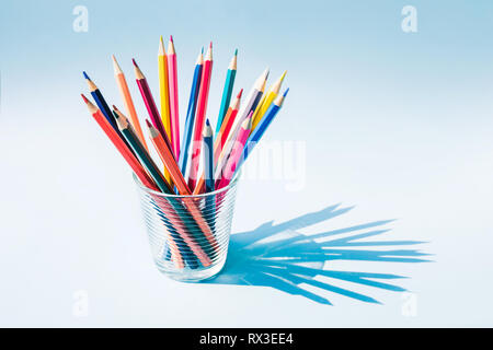 Crayon de couleur en verre tasse avec grande ombre sur fond pastel.la créativité d'idées concept Banque D'Images