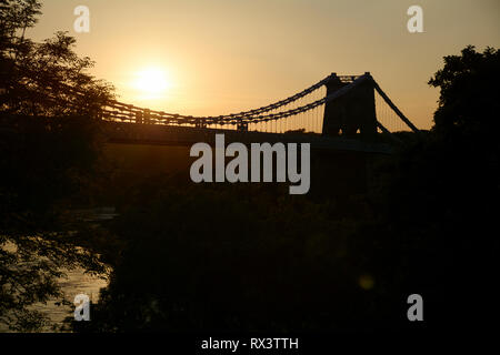 Le pont suspendu de Menai se joindre à Anglesey au coucher du soleil dans le Nord du Pays de Galles Banque D'Images