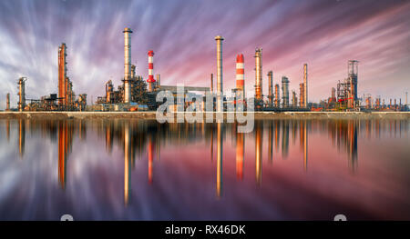 Raffinerie de pétrole au coucher du soleil avec la réflexion