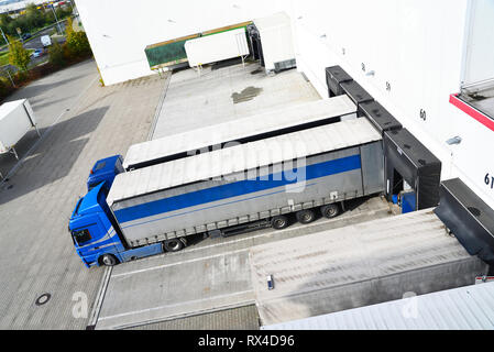 Les camions sont chargés de marchandises à l'entrepôt dans une compagnie maritime Banque D'Images