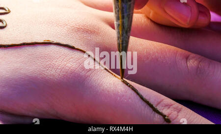 La conception de long en passant par les doigts. L'artiste est très bon en faisant la conception Banque D'Images
