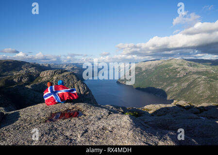 Preikestolen pathway. Couple avec le pavillon de la Norvège ressemble au panorama de l'Lysefjord. Attraction touristique. Ensoleillé dans les montagnes Banque D'Images