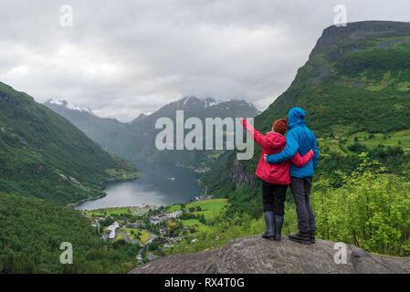 Vue sur le village touristique à Geiranger, Norvège. Les touristes sont à un point panoramique et regarder les montagnes et le Geirangerfjord Banque D'Images