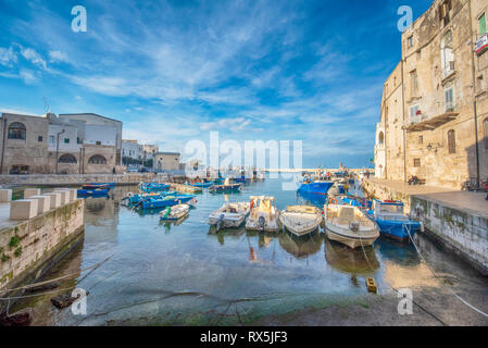 Vieux port de Monopoli province de Bari, dans la région des Pouilles. Bateaux dans le port de plaisance de Monopoli, Puglia, Italie. Plage de rochers et mur d'eau bleu Banque D'Images