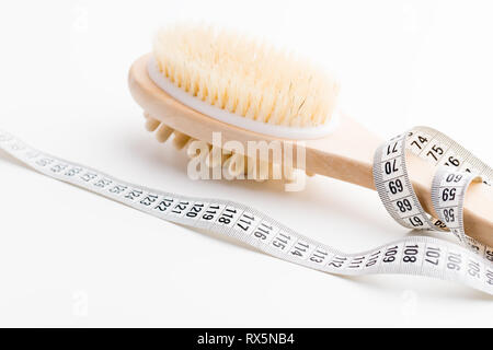 Brosse de massage à sec avec ruban de mesure sur blanc 24. Santé et alimentation. Concept de remise en forme. Banque D'Images