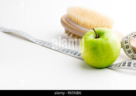 Brosse de massage à sec avec ruban et seul apple vert sur blanc 24. Banque D'Images