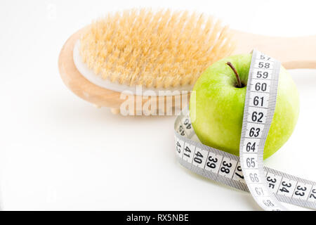 Brosse de massage à sec avec ruban et seul apple vert sur blanc 24. Banque D'Images