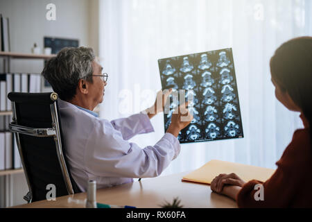 Asian médecin examiner l'IRM photo expliquer au patient Banque D'Images