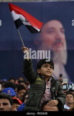 Bagdad, Iraq. 05Th Mar, 2019. Un partisan du leader musulman chiite et chef de parti Hikma Ammar al-Hakim est titulaire d'un drapeau comme il écoute son discours lors de la commémoration de l'assassinat de l'imam chiite Mohammed Baqir al Hakim - Journée des Martyrs irakiens sur. Ameer Al Mohmmedaw : Crédit/dpa/Alamy Live News Banque D'Images