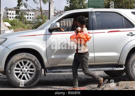 D'Aden, au Yémen. Mar 8, 2019. Un enfant vend des oranges à un conducteur de voiture passant à Aden, Yémen, le 8 mars 2019. Des milliers de jeunes Yéménites ont été poussées dans les rues à la suite d'un conflit militaire croissante qui a éclaté entre les forces du gouvernement du Yémen et les rebelles Houthi en 2015. Le nombre d'enfants des rues continue d'augmenter sur une base quotidienne que les combats se poursuivent, l'expansion pour inclure un plus grand nombre de provinces dans le pays arabe au milieu de l'absence de solutions politiques à la fin de quatre ans de guerre civile. Credit : Murad Abdo/Xinhua/Alamy Live News Banque D'Images