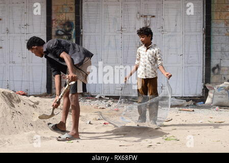 D'Aden, au Yémen. Mar 8, 2019. Un enfant yéménite fonctionne avec un homme sur un site de construction à Aden, Yémen, le 8 mars 2019. Des milliers de jeunes Yéménites ont été poussées dans les rues à la suite d'un conflit militaire croissante qui a éclaté entre les forces du gouvernement du Yémen et les rebelles Houthi en 2015. Le nombre d'enfants des rues continue d'augmenter sur une base quotidienne que les combats se poursuivent, l'expansion pour inclure un plus grand nombre de provinces dans le pays arabe au milieu de l'absence de solutions politiques à la fin de quatre ans de guerre civile. Credit : Murad Abdo/Xinhua/Alamy Live News Banque D'Images