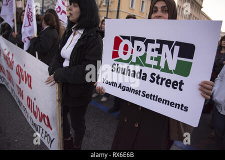 Athènes, Grèce. Mar 8, 2019. Une femme palestinienne est titulaire d'une plaque à l'encontre des colonies israéliennes. De gauche, féministes et des organisations de défense des droits ont organisé une manifestation en l'honneur de la Journée internationale de la femme et de la demande l'égalité de droits et de respect. Credit : Nikolas Georgiou/ZUMA/Alamy Fil Live News Banque D'Images