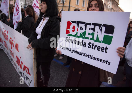 Athènes, Grèce. 8Th Mar 2019. Une femme palestinienne est titulaire d'une plaque à l'encontre des colonies israéliennes. De gauche, féministes et des organisations de défense des droits ont organisé une manifestation en l'honneur de la Journée internationale de la femme et de la demande l'égalité de droits et de respect. Credit : Nikolas Georgiou/Alamy Live News Banque D'Images