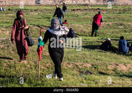 8 mars 2019 - Gaza, Palestine, 8 mars 2019. Des manifestants palestiniens brûlent des pneus et des vagues le drapeau palestinien, avec quelques pierres de hurling vers la clôture, dans la région de Malika à l'est de la bande de Gaza. Des manifestants palestiniens s'étaient rassemblés à différents endroits le long de la frontière au cours de cette Gaza-Israeli vendredi 50e Grande Marche du retour rallye, et selon le ministère de la santé dans la bande de Gaza cinq Palestiniens ont été blessés dans ce Vendredi, Mars 1 dans un état critique. Selon l'armée israélienne, des ballons incendiaires chargé d'explosifs ont été libérés de la bande de Gaza vers le sud d'Israël. Banque D'Images