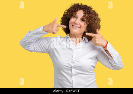 Beau milieu des affaires senior femme ager sur fond isolé sourire confiant montrant et en pointant les doigts avec les dents et bouche. Conce Santé Banque D'Images