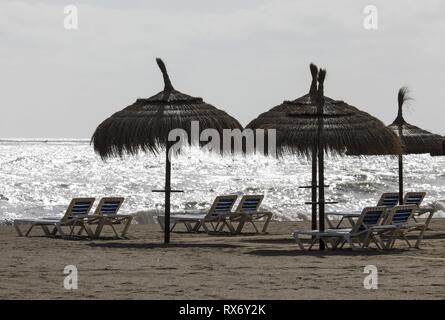 Les chaises longues et parasols sur la plage déserte à Torremolinos, Espagne, 13. Février 2019. L'économie espagnole est en attente de voir comment la Grande-Bretagne du futur départ de l'Union européenne pourrait s'appliquer à l'Espagne. Dans le monde d'utilisation | Banque D'Images