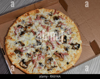 Pizza aux champignons et au jambon en boîte de carton Banque D'Images