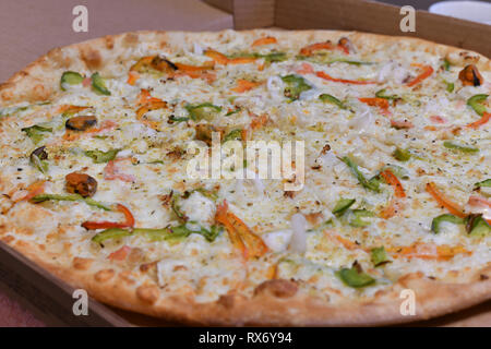 Pizza aux fruits de mer et légumes en boîte de carton Banque D'Images