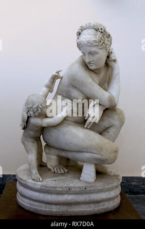 Aphrodite accroupie avec Cupidon. Sculpture de marbre (2e siècle) à partir d'un original grec de la période hellénistique. Naples, Italie. Banque D'Images