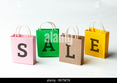 Des sacs de couleur avec l'inscription la vente sur fond blanc Banque D'Images